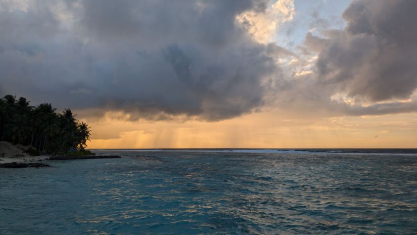 a storm approaches fulhadhoo, dark clouds on the horizon over the bay of the harbour
